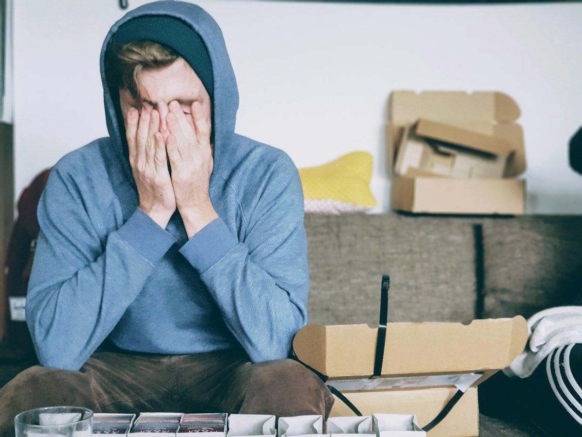 A tired person resting their head in their hands at a desk, conveying exhaustion