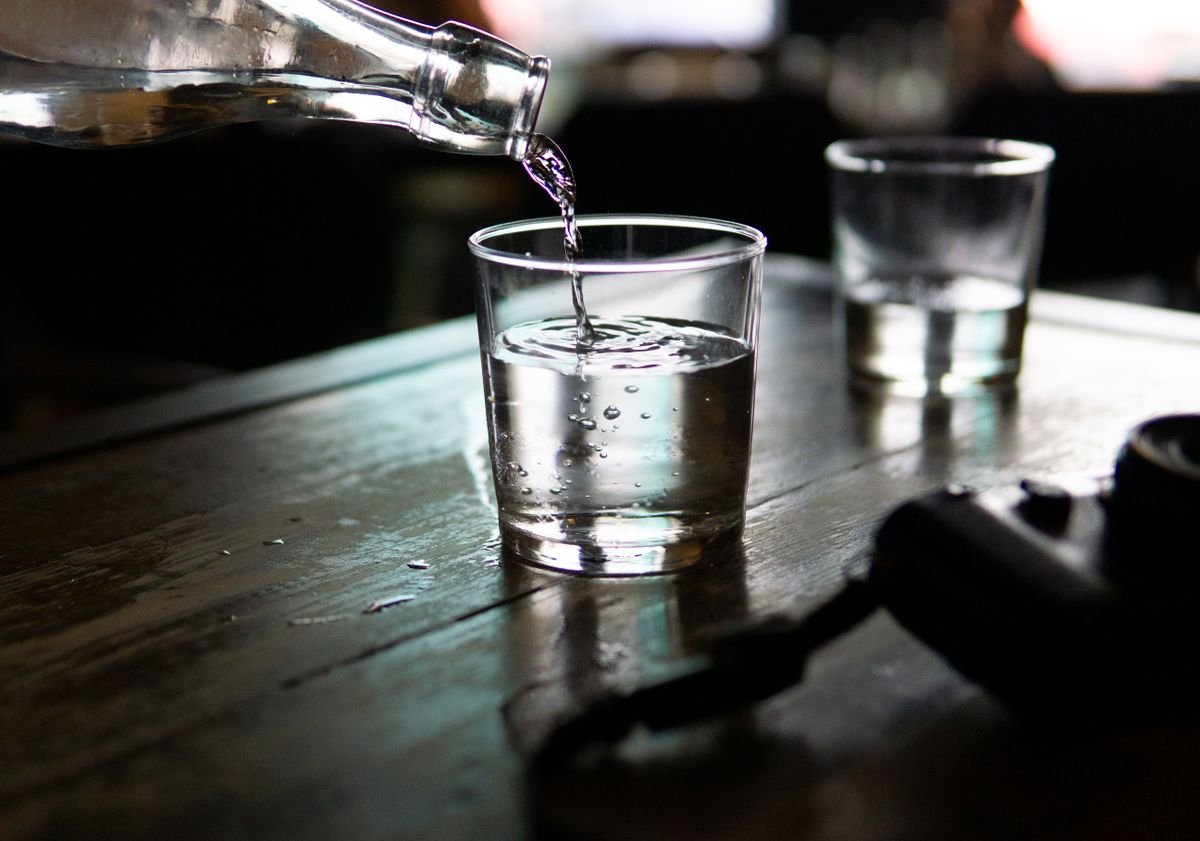 Clear glass being filled with water, representing water-only fasting