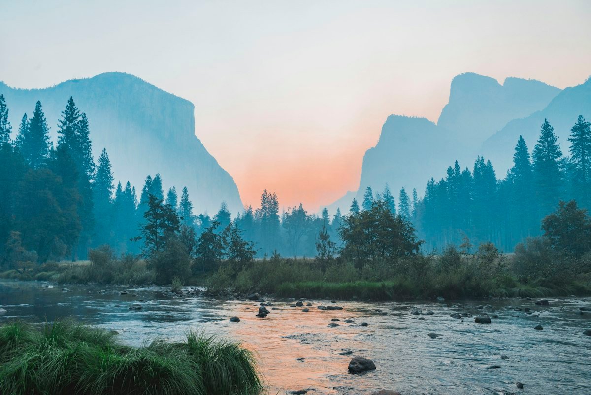 A calm natural landscape at sunrise, suggesting space to recover